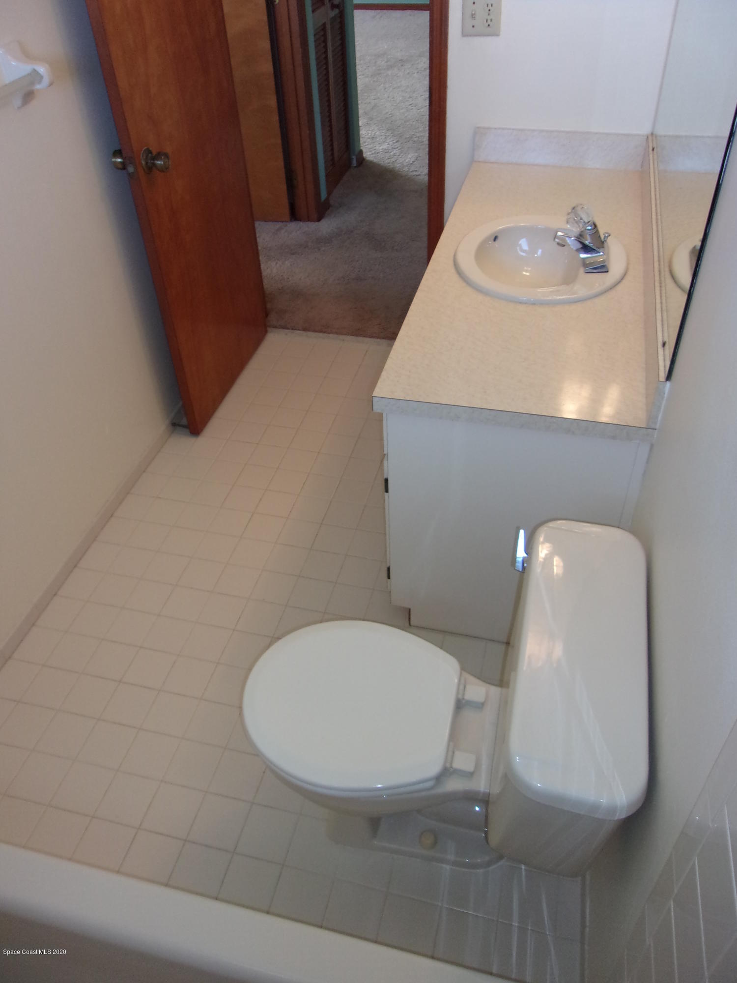 418 South Atlantic Avenue, Unit 3 Cocoa Beach, FL 32931 - Photo 24 of 29 a bathroom with a toilet and a mirror