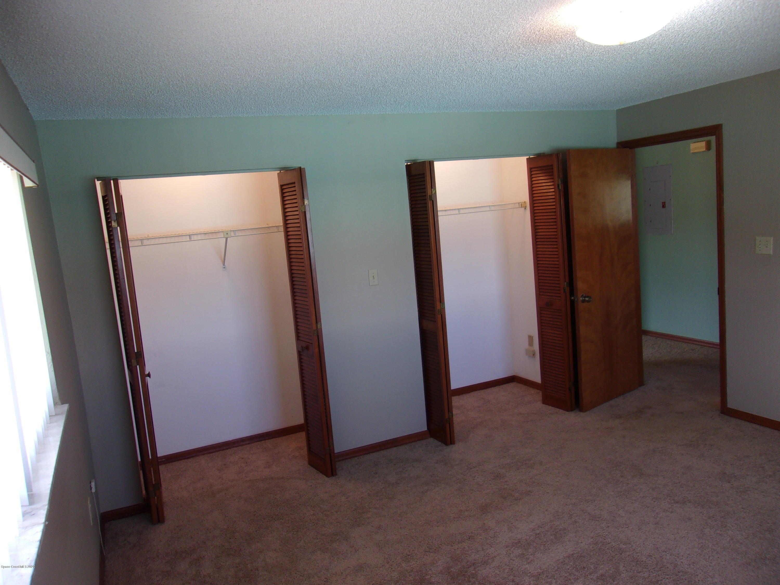 418 South Atlantic Avenue, Unit 3 Cocoa Beach, FL 32931 - Photo 27 of 29 an empty room with closet and mirror
