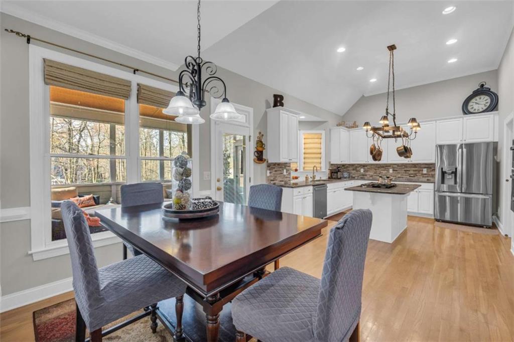 3540 Sentry View Trace Suwanee, GA 30024 - Photo 16 of 70 a kitchen with stainless steel appliances granite countertop table chairs and wooden floor