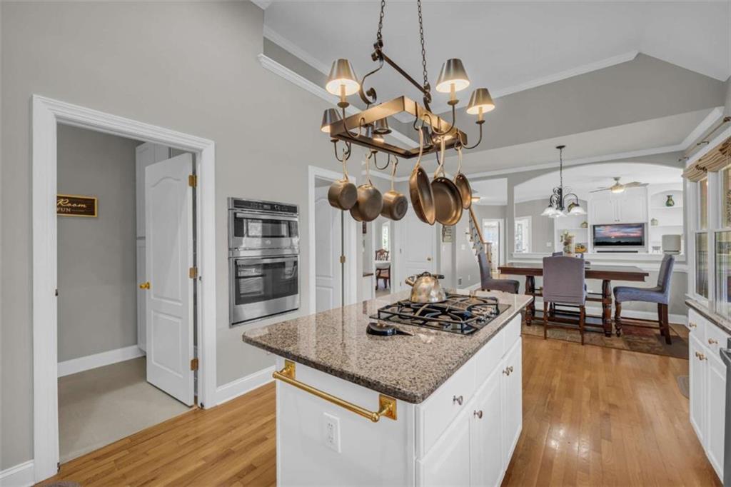 3540 Sentry View Trace Suwanee, GA 30024 - Photo 22 of 70 a kitchen with stainless steel appliances granite countertop a stove oven and a dining table with wooden floor