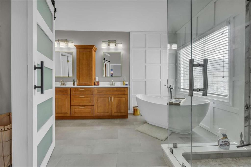 3540 Sentry View Trace Suwanee, GA 30024 - Photo 36 of 70 a bathroom with a tub sink vanity and mirror