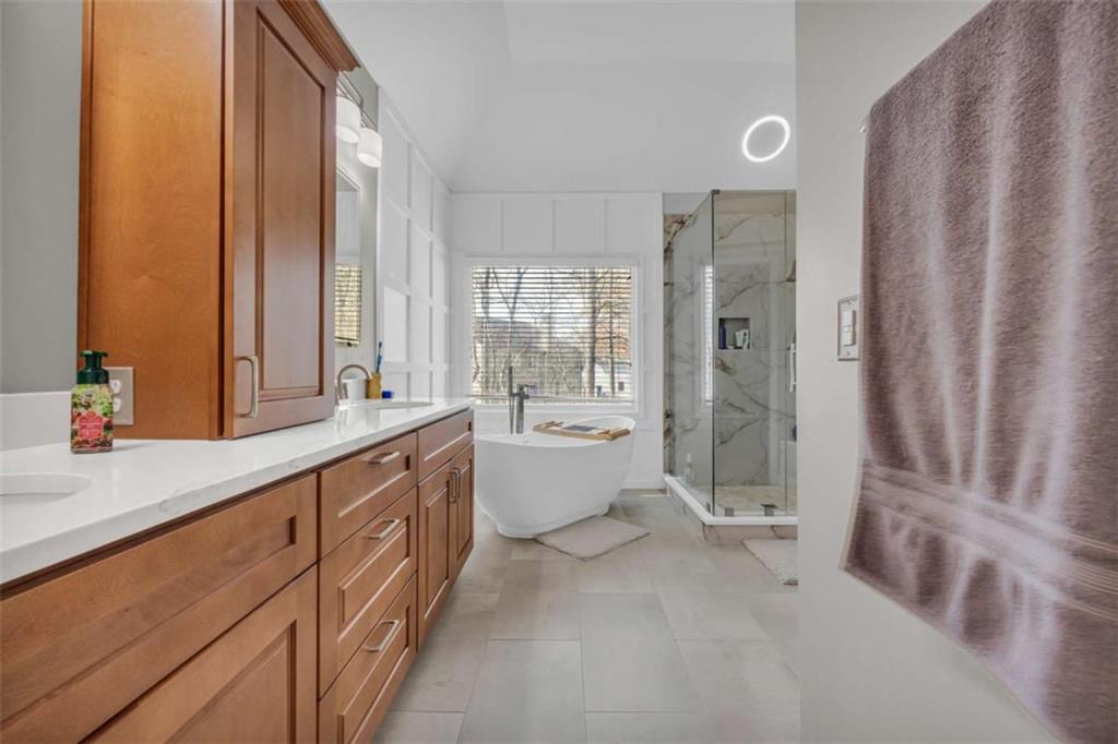 3540 Sentry View Trace Suwanee, GA 30024 - Photo 40 of 70 a large bathroom with a double vanity sink a large mirror and a bathtub