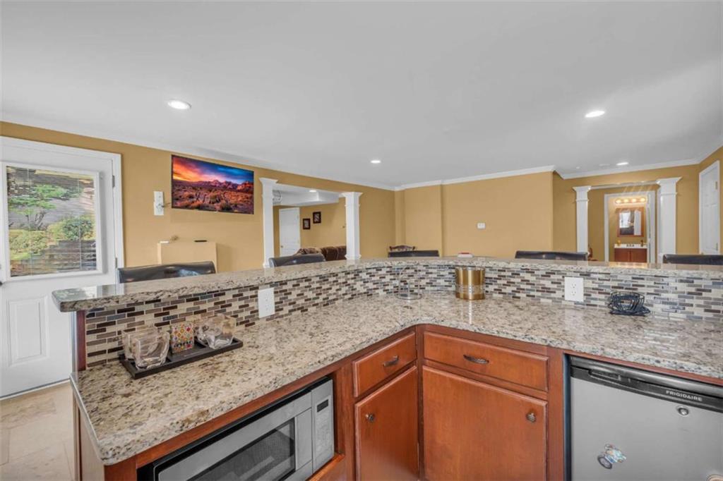 3540 Sentry View Trace Suwanee, GA 30024 - Photo 51 of 70 a kitchen with stainless steel appliances granite countertop a sink and a wooden cabinets