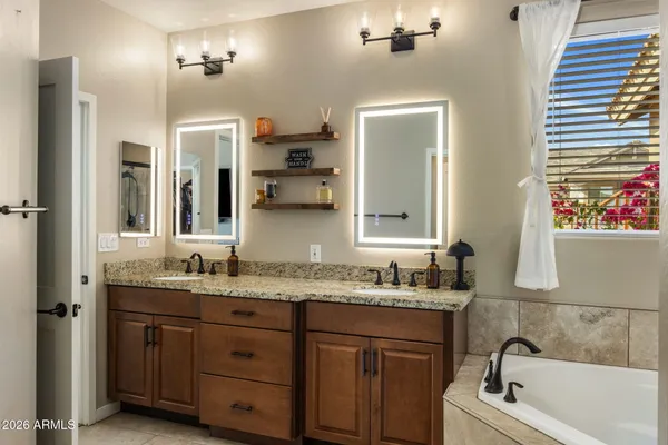 a bathroom with a granite countertop sink mirror and bathtub