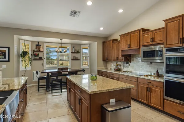 a kitchen with granite countertop a sink counter top space appliances and cabinets