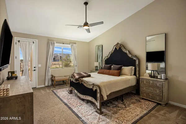 a bedroom with a large bed and a flat tv screen on dresser