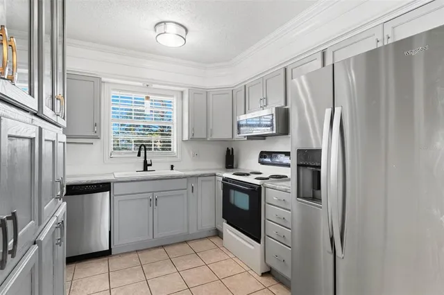 a kitchen with stainless steel appliances granite countertop a refrigerator sink and stove