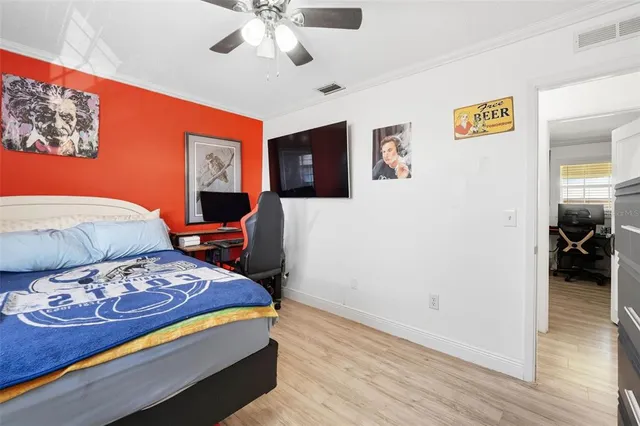 a bedroom with a bed and wooden floor