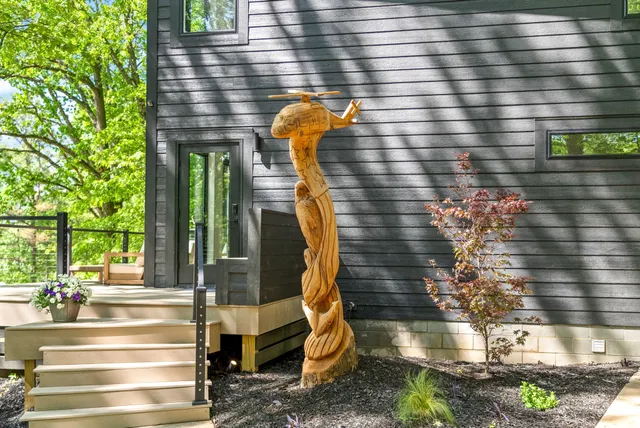 a backyard of a house with large trees and wooden fence