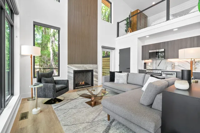 a living room with furniture fireplace and a large window