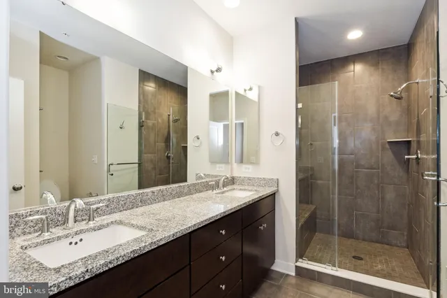a bathroom with a granite countertop sink mirror and shower