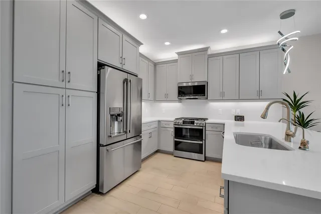 a kitchen with granite countertop a refrigerator and a stove top oven