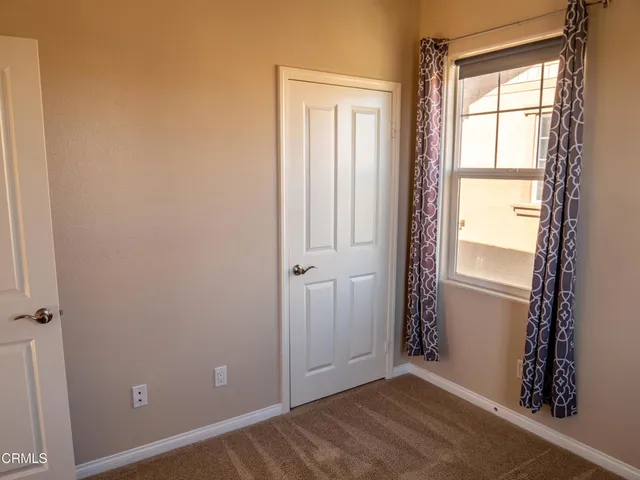 a view of an empty room with window and gate