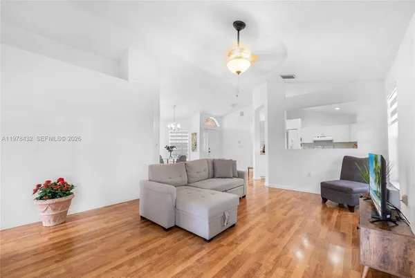 a living room with furniture and a wooden floor