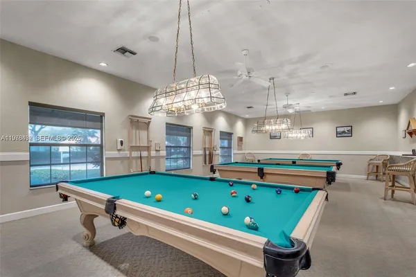 a room with pool table and windows