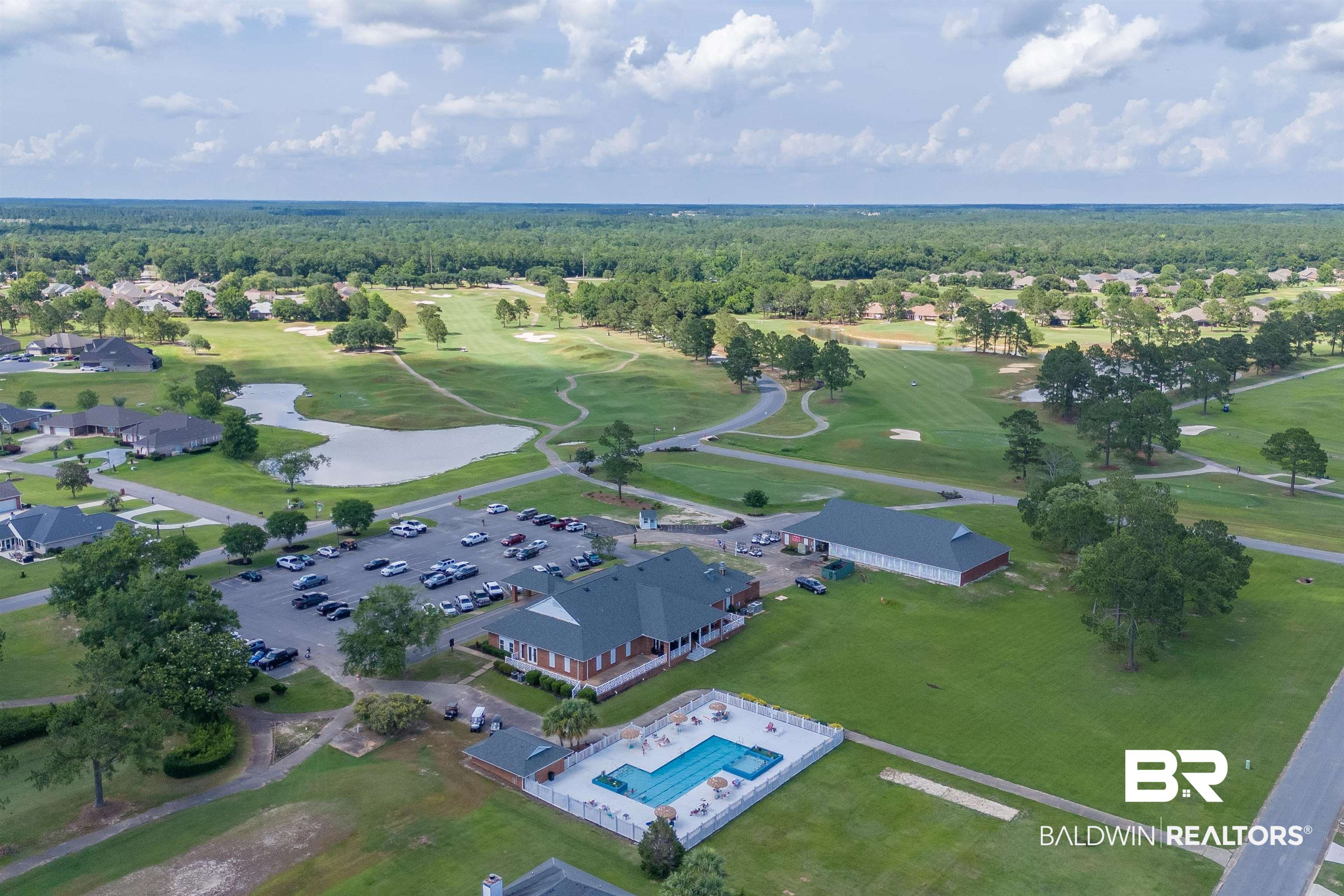 22739 Inverness Way Foley, AL 36535 - Photo 74 of 80 Drone / aerial view of a golf club, a forest, a pool area, and a nearby body of water