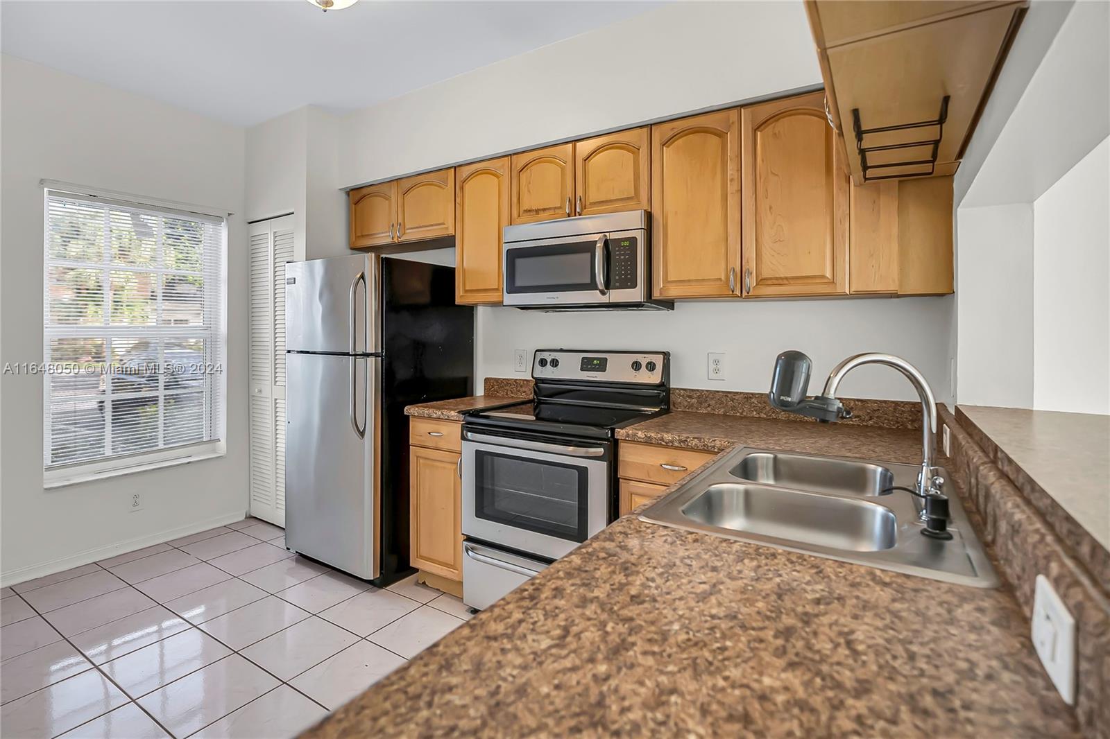 56 Truman Drive Weston, FL 33326 - Photo 3 of 24 a kitchen with stainless steel appliances granite countertop a refrigerator sink and stove