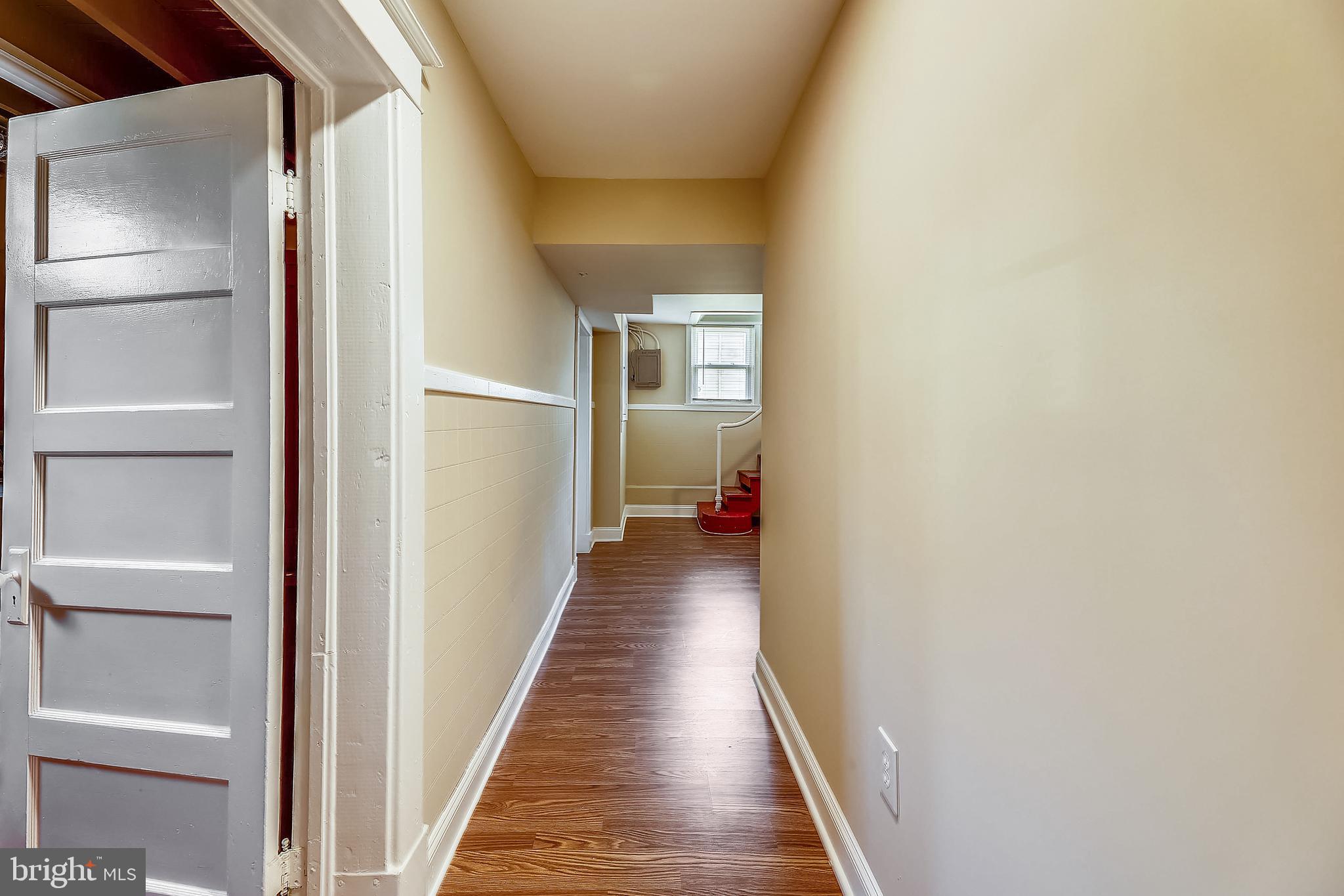 1321 Maple Avenue Baltimore, MD 21227 - Photo 12 of 30 a view of a hallway with wooden floor and a bathroom