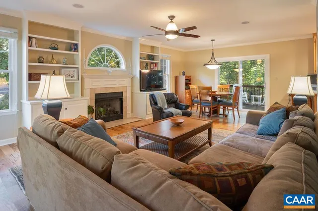 a living room with furniture a fireplace and a large window