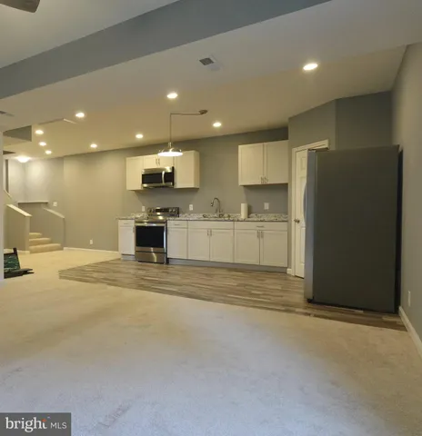 a view of kitchen with refrigerator and microwave