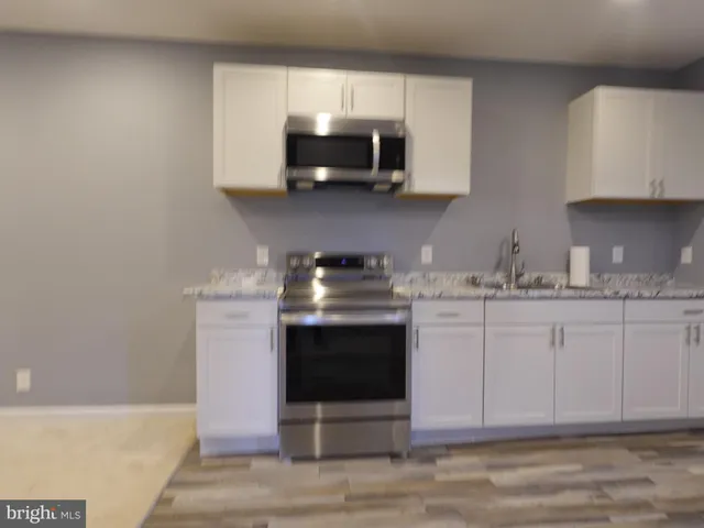 a kitchen with stainless steel appliances granite countertop a stove a microwave a sink and cabinets