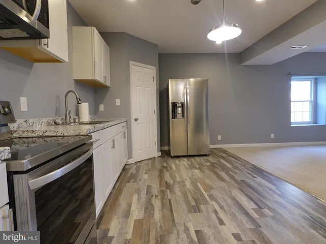 a kitchen with granite countertop a sink cabinets and stainless steel appliances