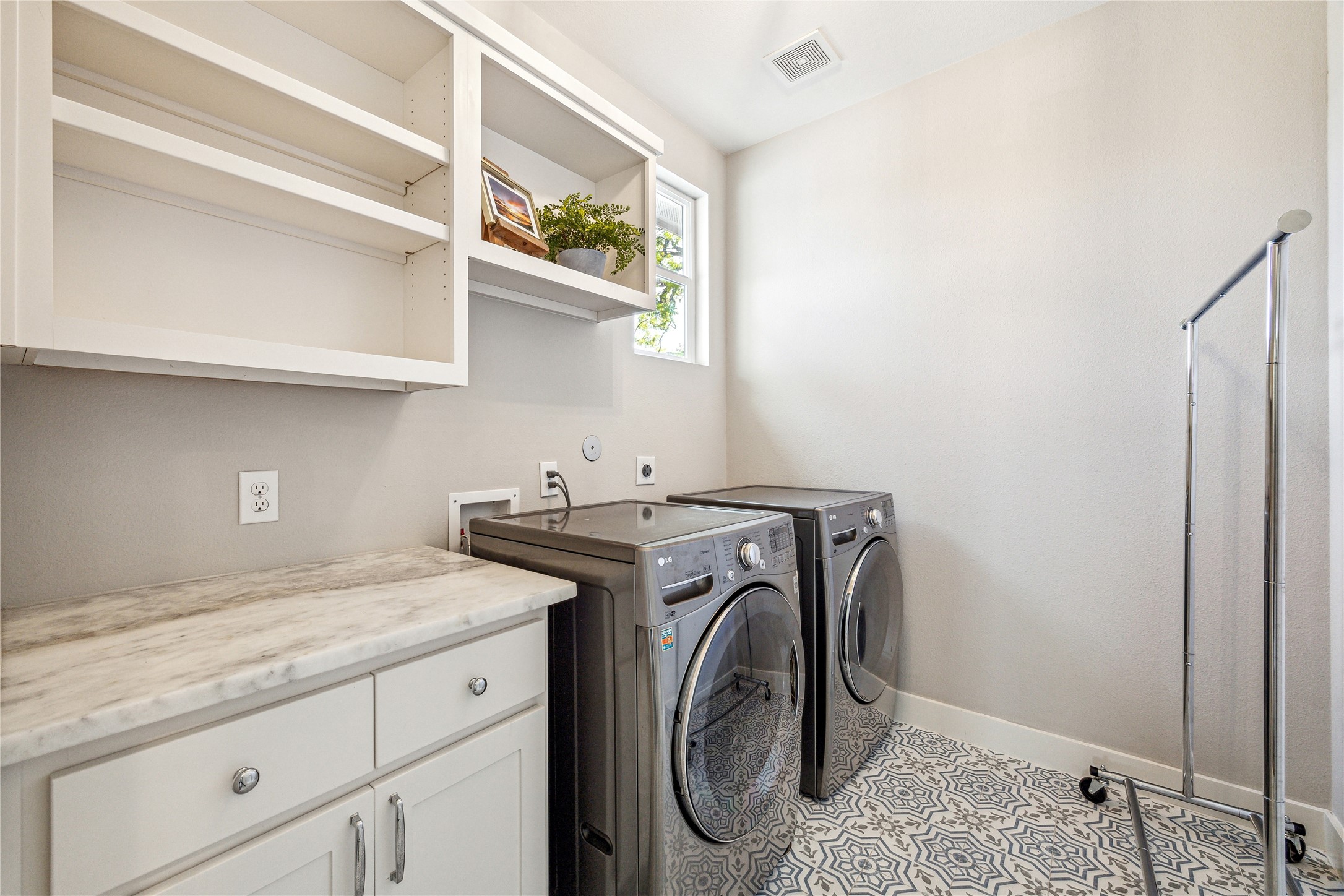603 Vincent Street Houston, TX 77009 - Photo 20 of 26 The laundry room is conveniently located on the second floor and includes counter prep space + overhead storage. The tasteful decorative floor tile finishes off the space nicely.
