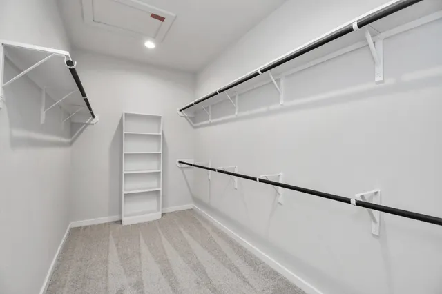 a view of walk in closet with empty racks