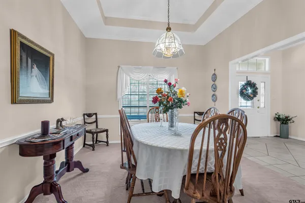 a view of a dining room with furniture and chandelier