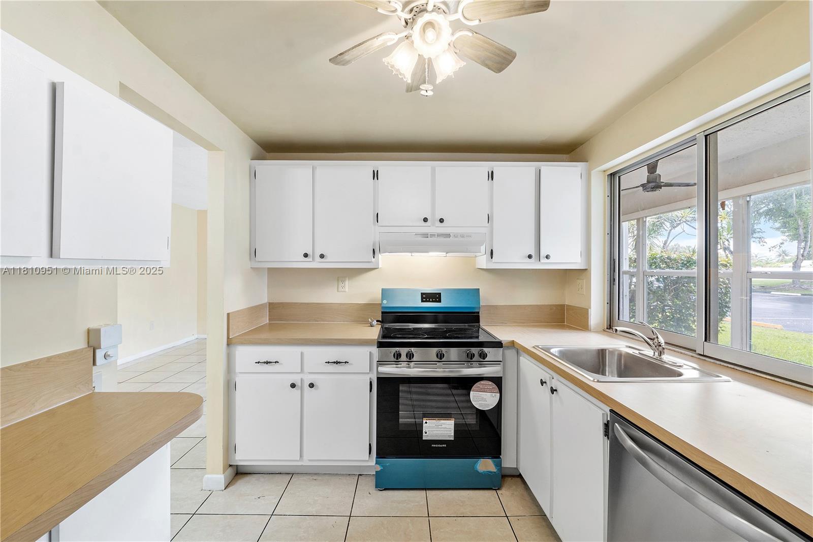 9091 Lime Bay Boulevard, Unit 110 Tamarac, FL 33321 - Photo 11 of 40 a kitchen with cabinets appliances and a sink