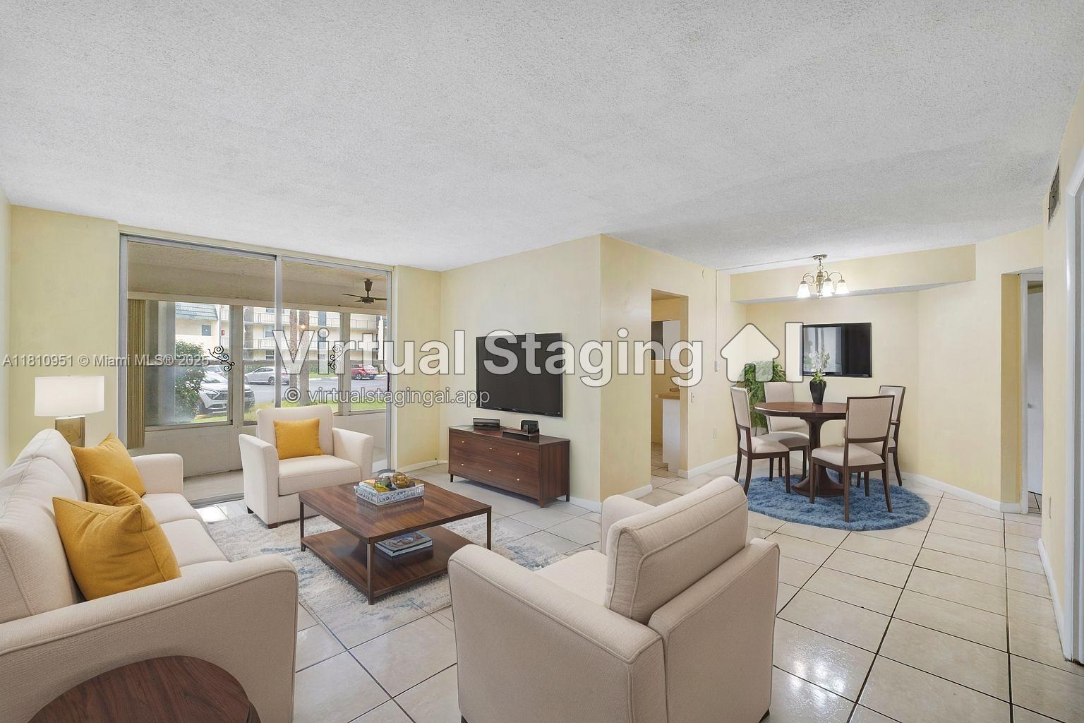 9091 Lime Bay Boulevard, Unit 110 Tamarac, FL 33321 - Photo 16 of 40 a living room with furniture and a large window