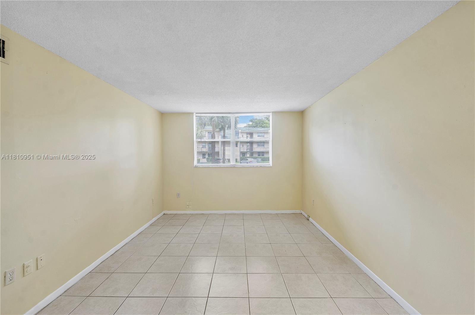 9091 Lime Bay Boulevard, Unit 110 Tamarac, FL 33321 - Photo 21 of 40 an empty room with a window