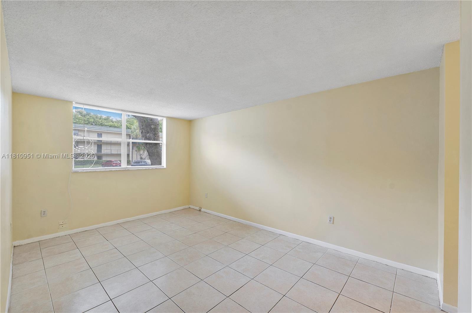9091 Lime Bay Boulevard, Unit 110 Tamarac, FL 33321 - Photo 9 of 40 an empty room with windows