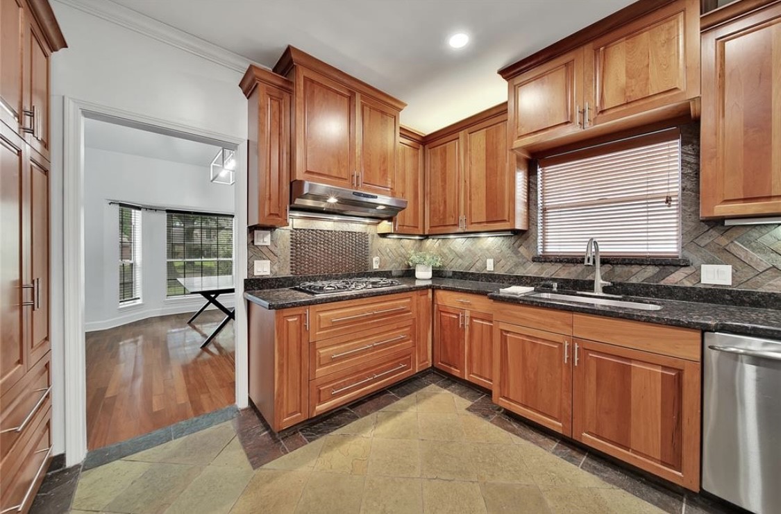 12922 Lentando Drive Cypress, TX 77429 - Photo 12 of 41 a kitchen with granite countertop wooden cabinets a sink and dishwasher a stove with wooden floors