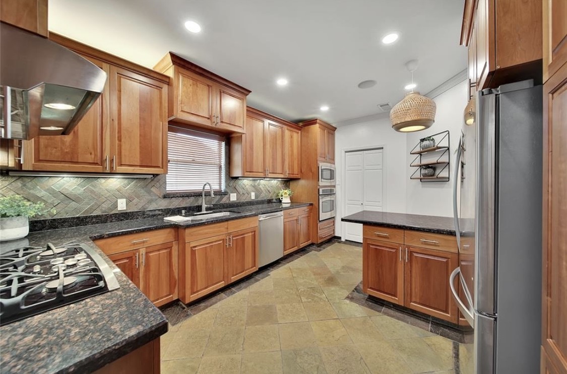 12922 Lentando Drive Cypress, TX 77429 - Photo 13 of 41 a kitchen with stainless steel appliances granite countertop a stove a sink and a refrigerator