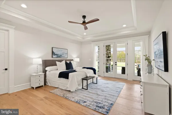 a living room with a bed furniture flat screen tv and a table