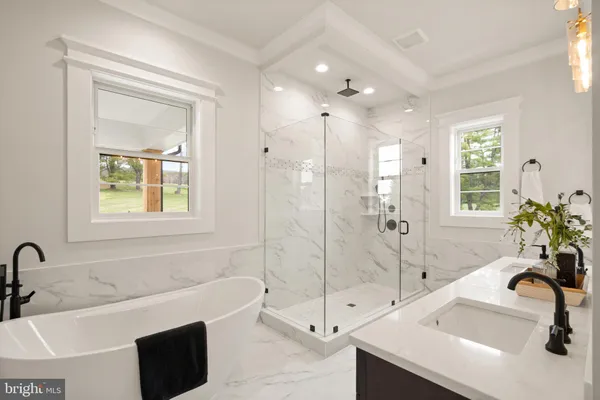 a bathroom with a tub sink and mirror