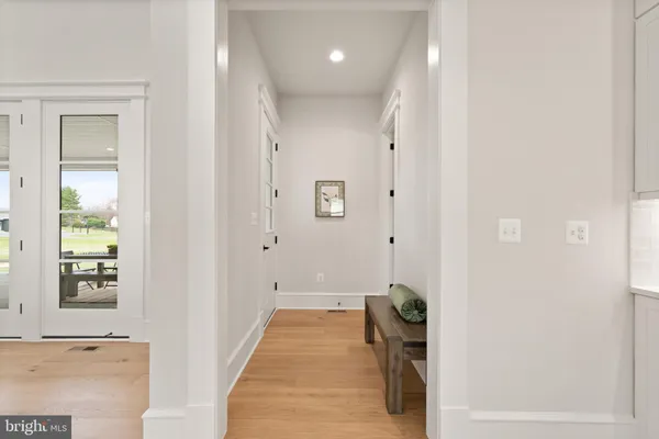 a view of a hallway with entryway wooden floor and windows