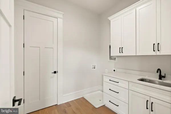 a kitchen with white cabinets and sink