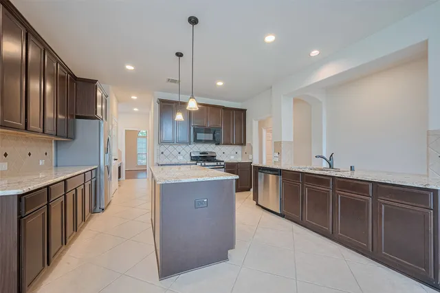 a large kitchen with stainless steel appliances lots of counter top space