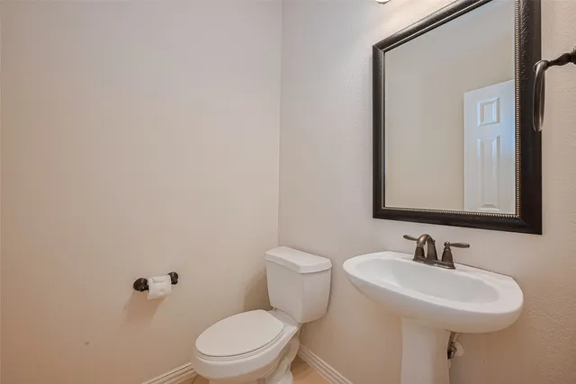 a bathroom with a sink a toilet and mirror