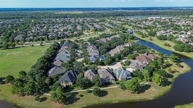 an aerial view of a residential houses with outdoor space and trees