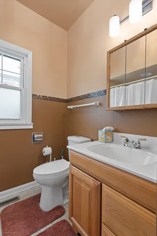 a bathroom with a sink a toilet and mirror