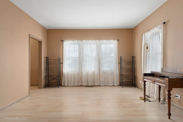 an empty room with kitchen view and a window