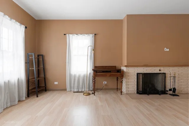 an empty room with fireplace and windows