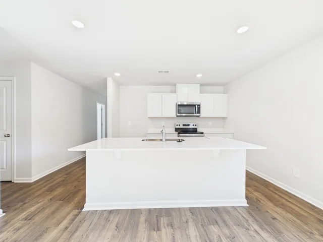 a view of kitchen with stainless steel appliances granite countertop refrigerator sink and stove