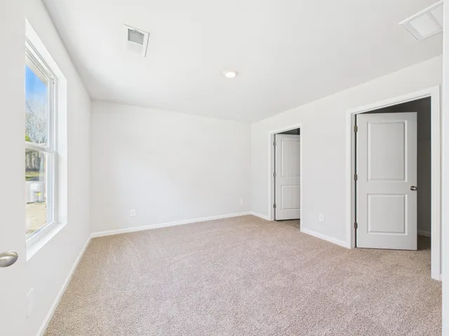 an empty room with windows and closet