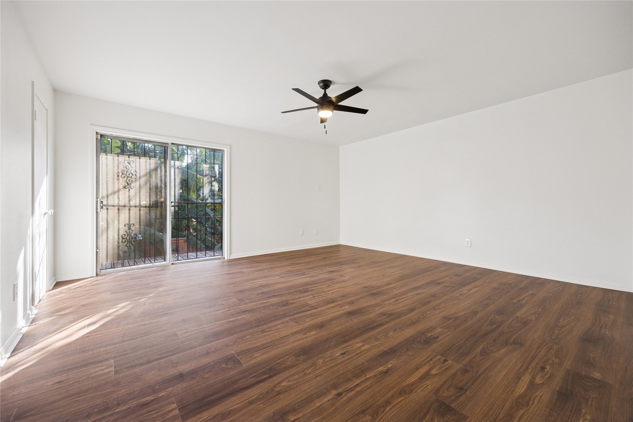 705 Harold Street, Unit 2 Houston, TX 77006 - Photo 7 of 15 an empty room with wooden floor and windows