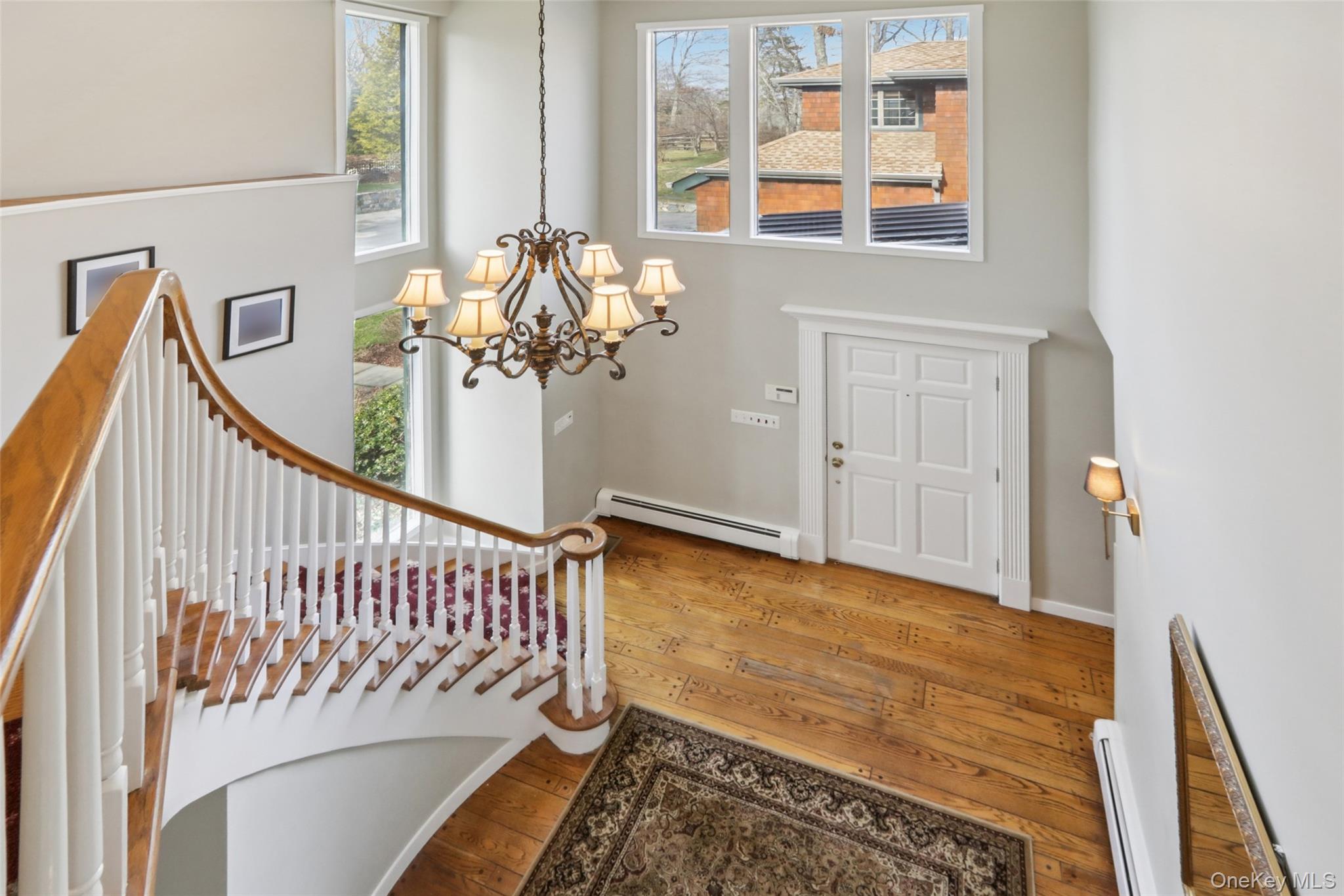 27 Cat Ridge Road North Salem, NY 10560 - Photo 29 of 46 Entryway with plenty of natural light, hardwood / wood-style flooring, a baseboard heating unit, a chandelier, and a high ceiling