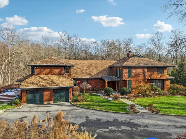 an aerial view of residential house with outdoor space and trees all around